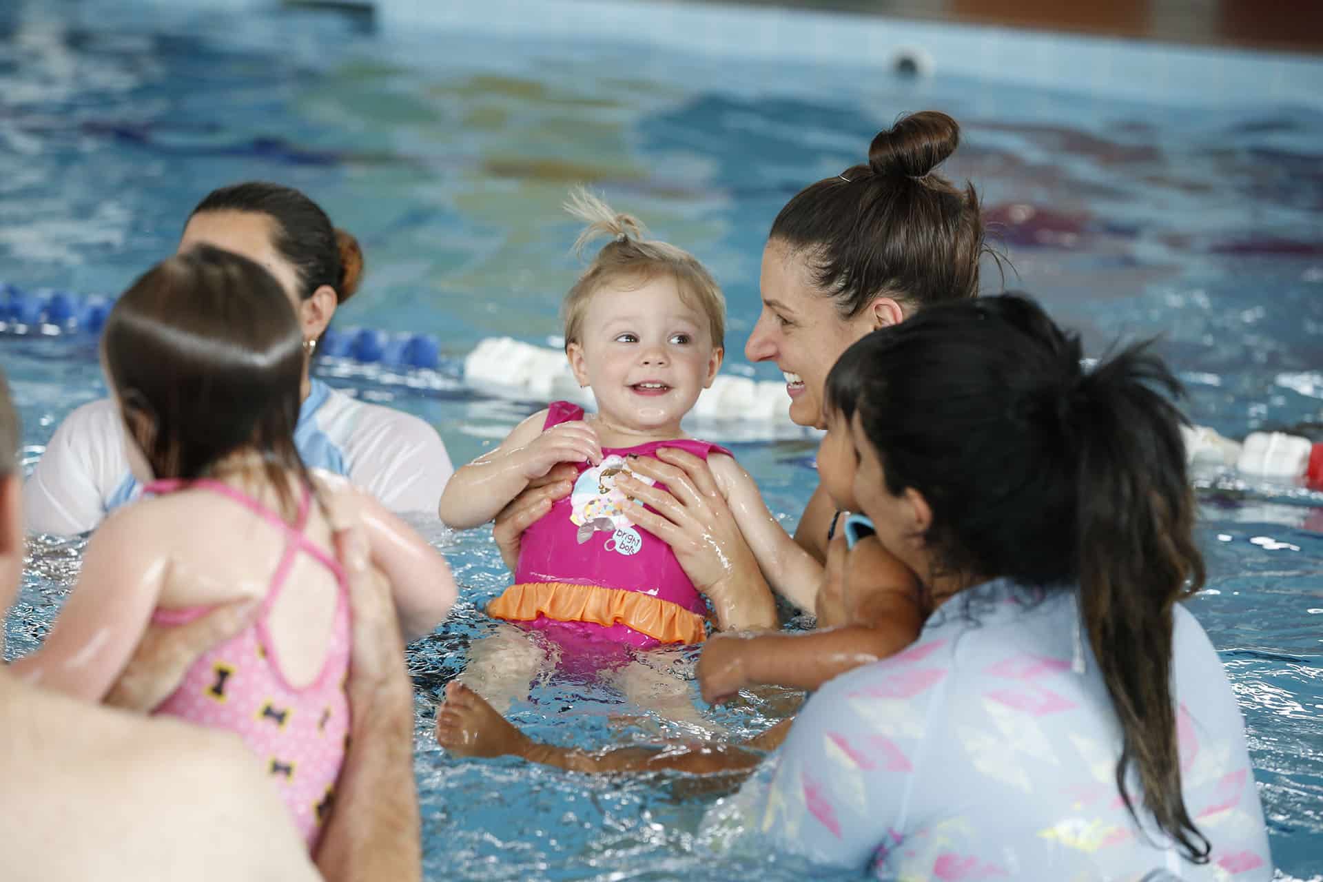 Baby Swim Lessons Happening In A Pool With Mother And Baby Daughter Present